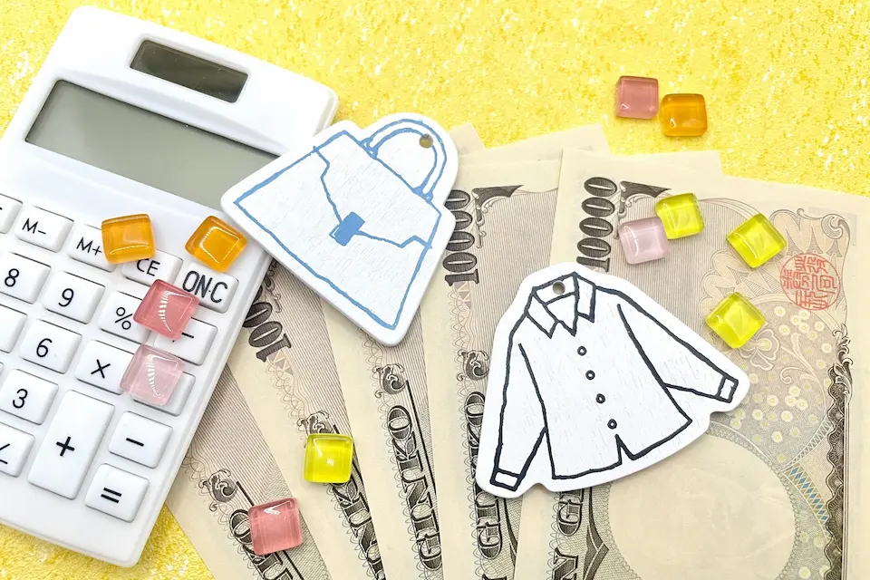 1万円札5枚と電卓と、ファッショングッズのイメージ画像