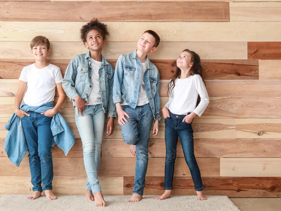 4人の子供が楽しそうに壁際に立っている画像