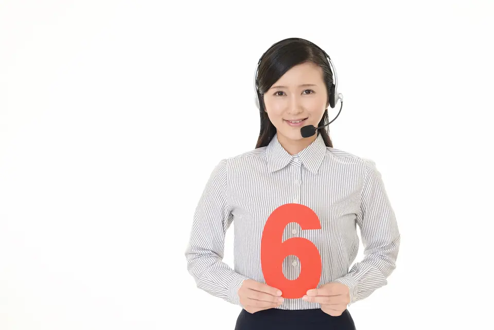 数字の６を両手でもつ女性