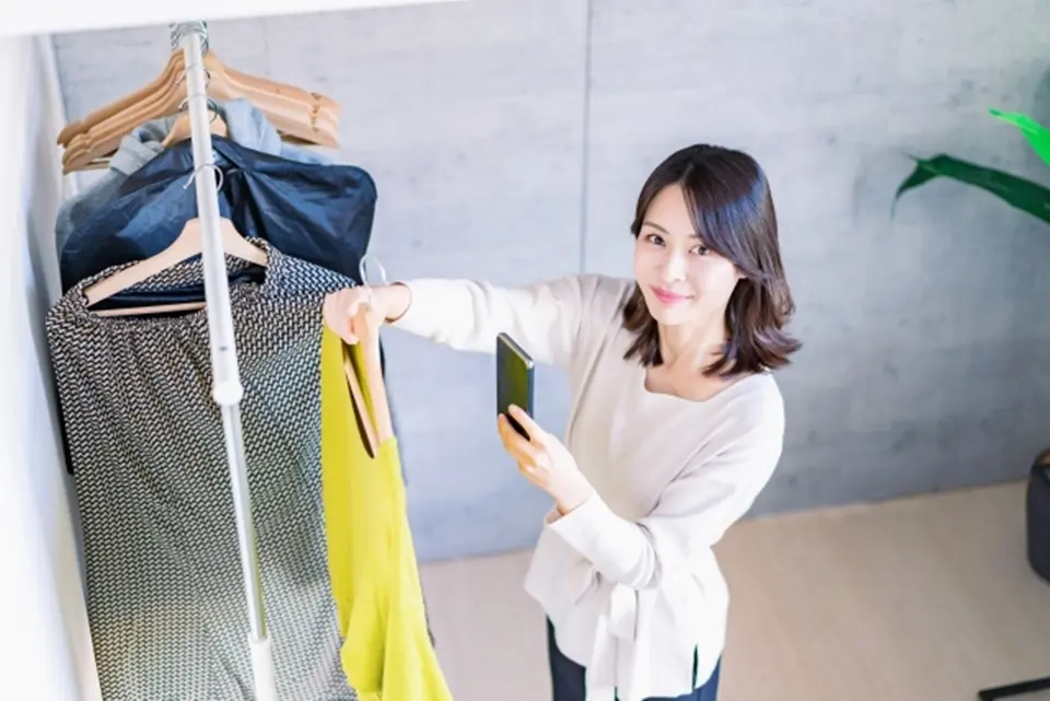 店舗でアパレルを撮影する女性