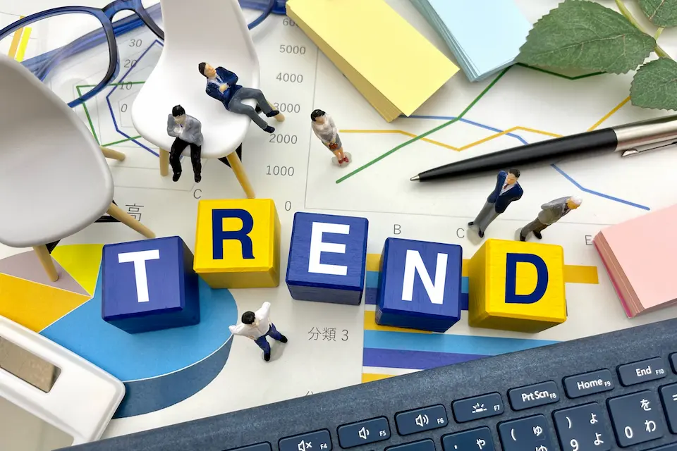 TRENDの文字とマーケティング資料、ビジネスパーソンのイメージ画像