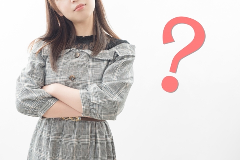 腕組みをする女性とクエッションマーク