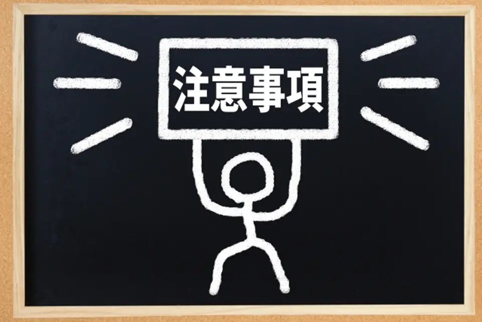 黒板に注意事項という文字を持ち上げる人のイラスト