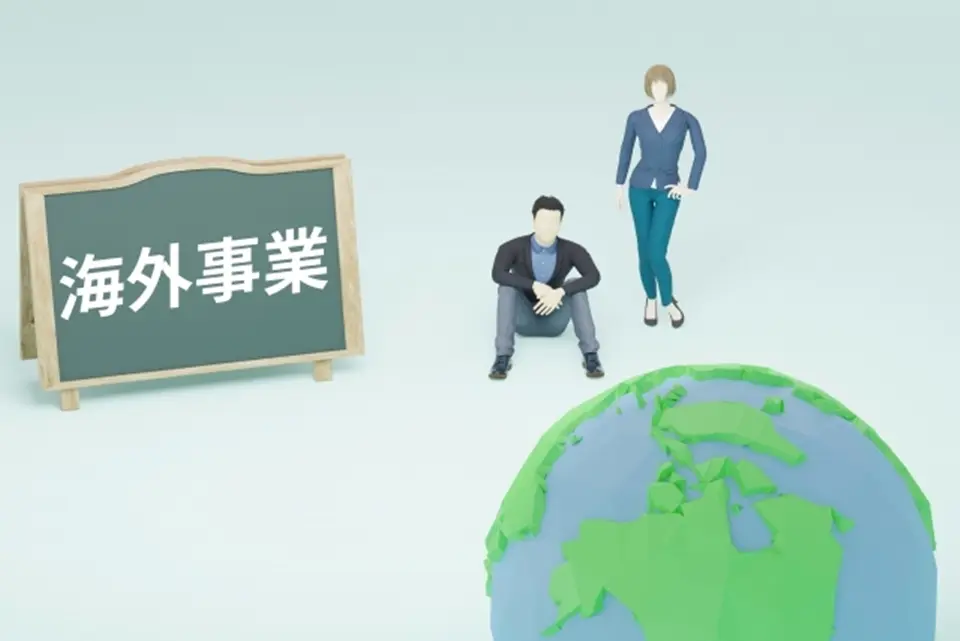 海外事業という看板、地球義の前にいる男女