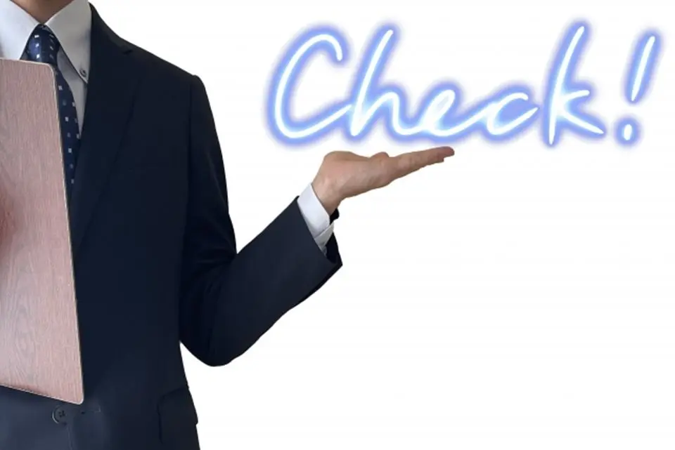 CHECKと言う文字を手の平の上で示すスーツ姿の男性の画像