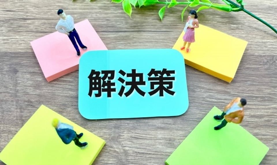 解決策という文字を中央にして立つ４人の男女のイメージ画像